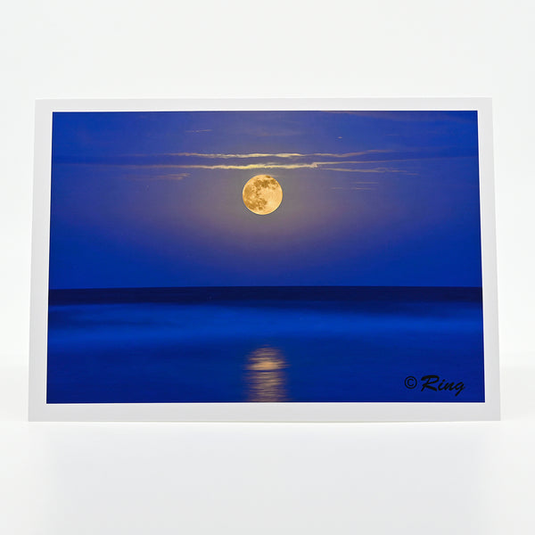 A super moon rising over the ocean sea photograph on a greeting card