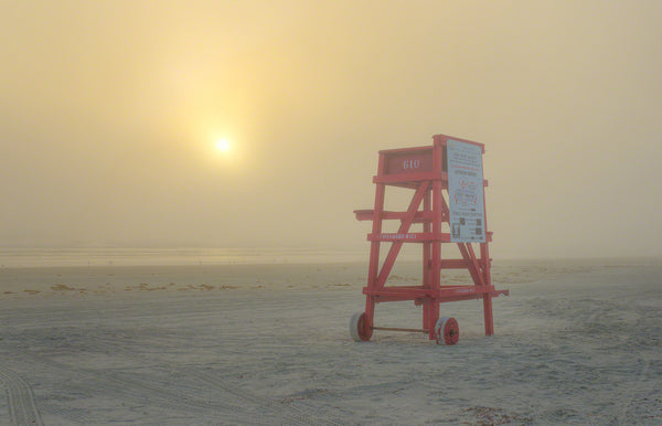 A photo of a red life guard stand on the beach