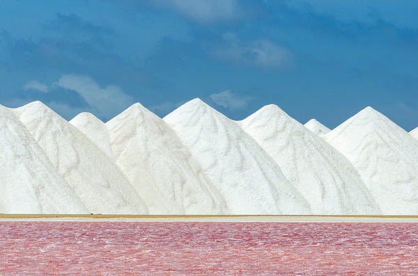 A photo of a pink salt pan and a mountain of salt in Bonaire.