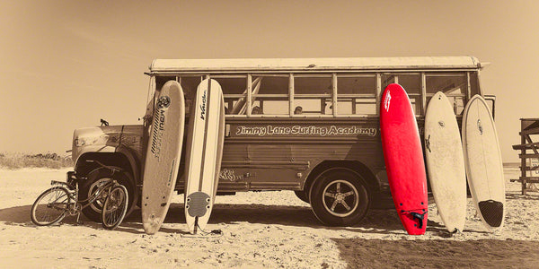 A photo of a bus with surf boards on the beach