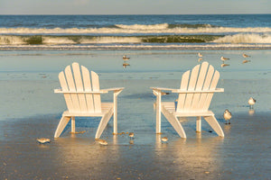 A photo of a pair of Adirondack Chairs on the beach