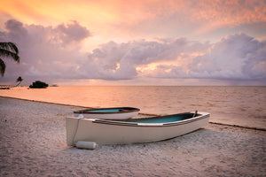 Two rustic boats on a beach at sunrise