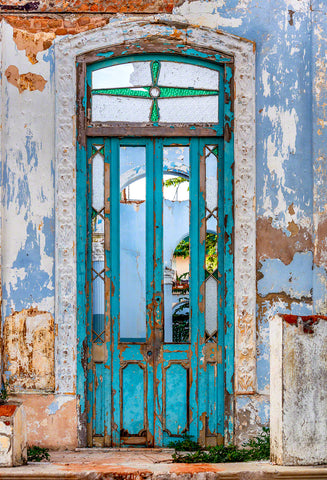 A photo of a turquoise colored rustic door on a home in Havana, Cuba
