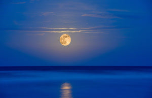 A photo of a super moon rising out of the ocean