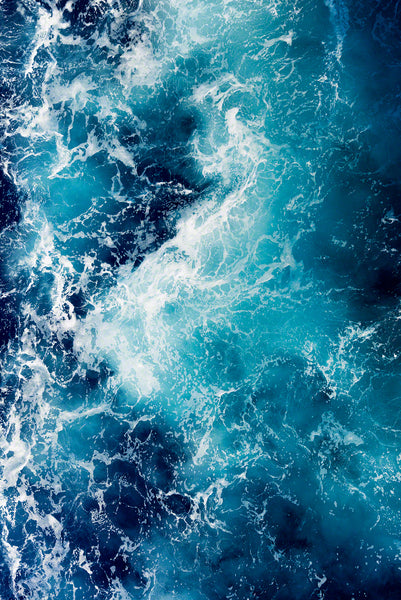A closeup photo of the beautiful blue Caribbean water with sea foam