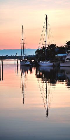 A photo of two sailboats at sunrise in New Smyrna Beach, Florida