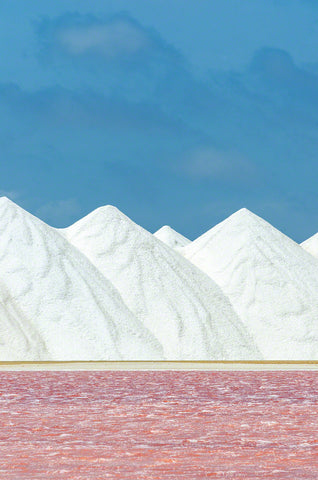 A photo of a pink salt pan and a mountain of salt in Bonaire.