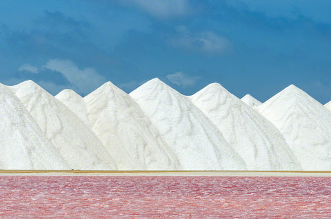 A photo of a pink salt pan and a mountain of salt in Bonaire. 