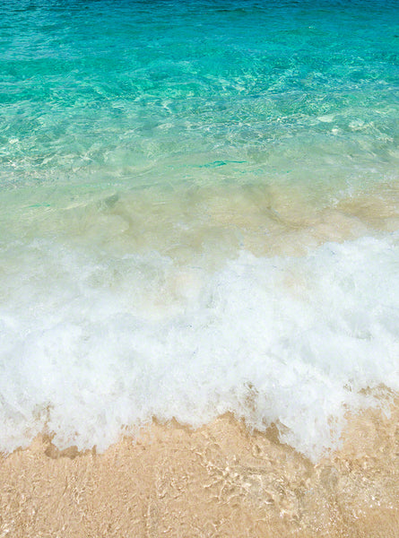 A photo of clear turquoise water crashing onto the beach in the Bahamas